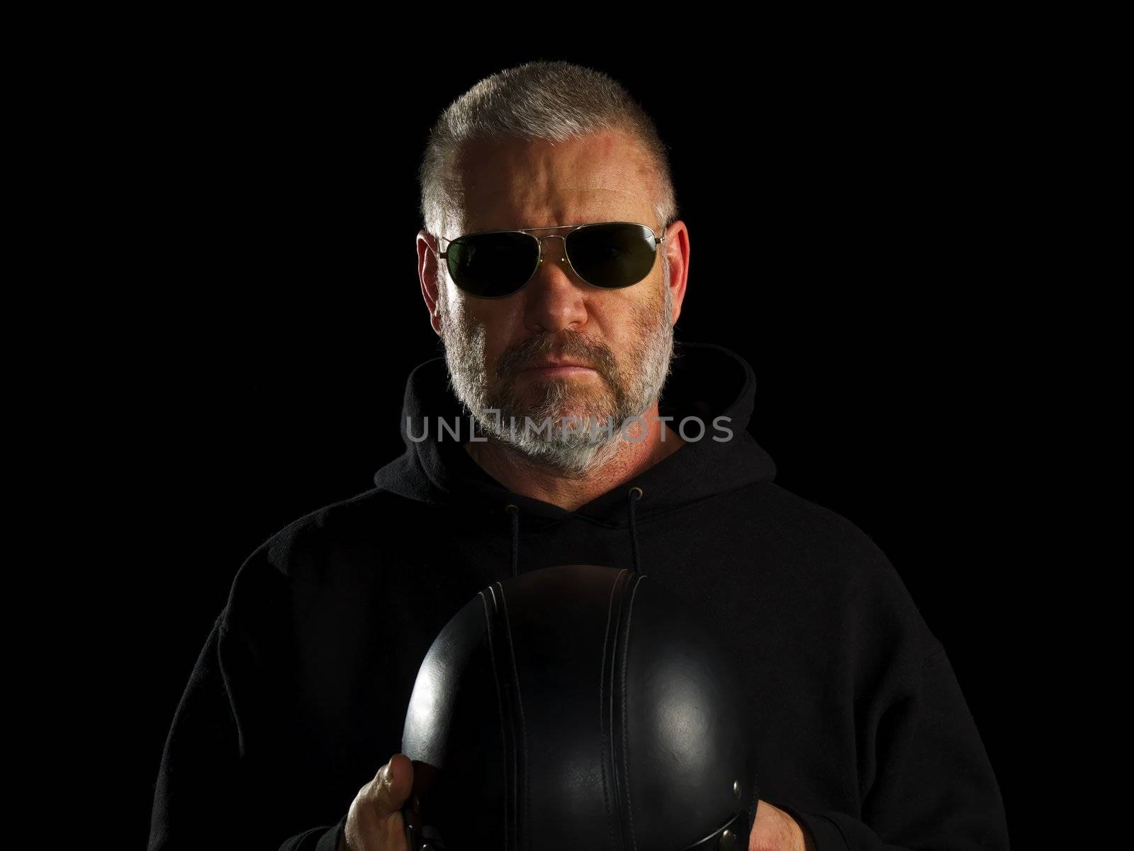Biker on black background holding his half hat helmet