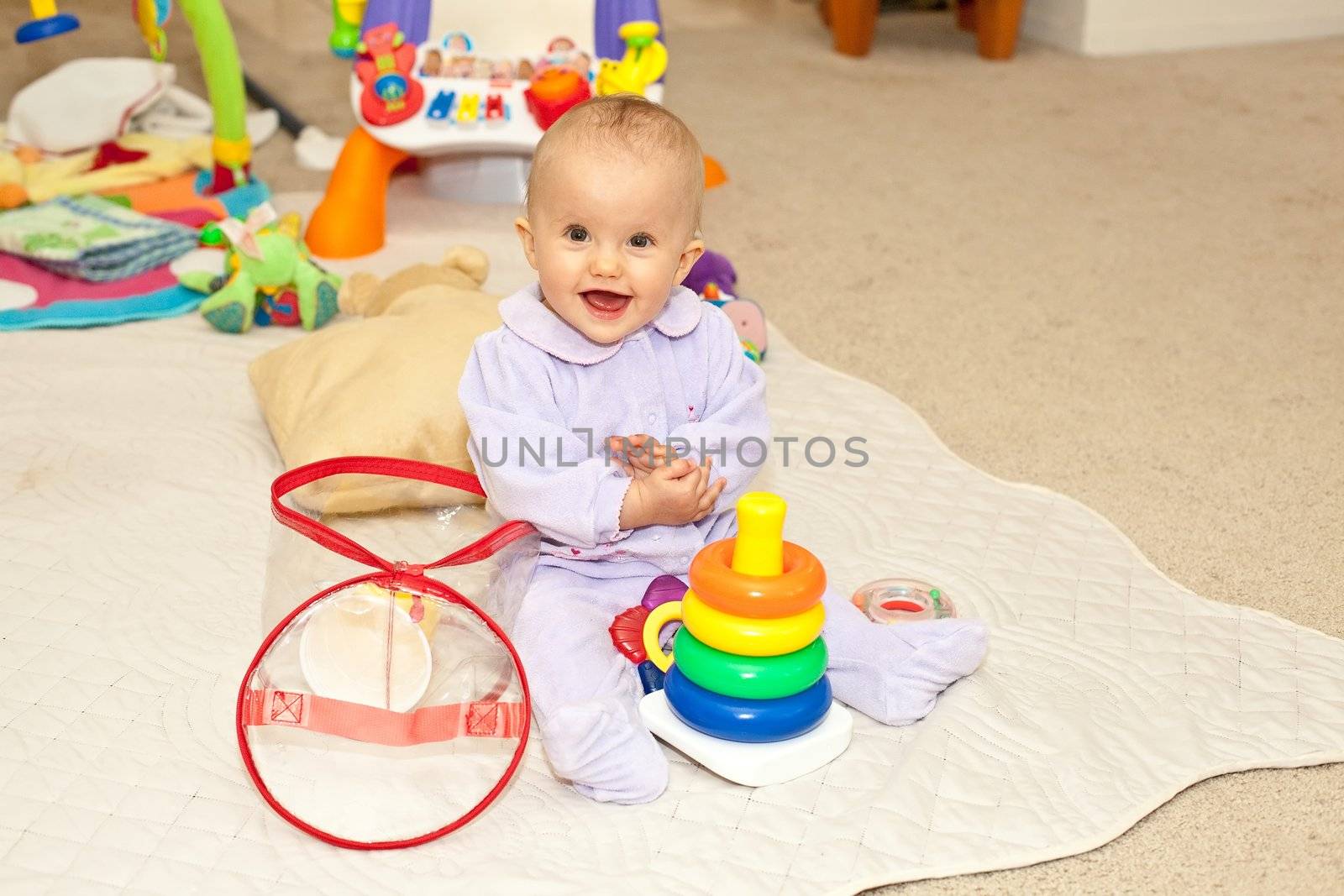 Caucasian baby girl playing on a floor.