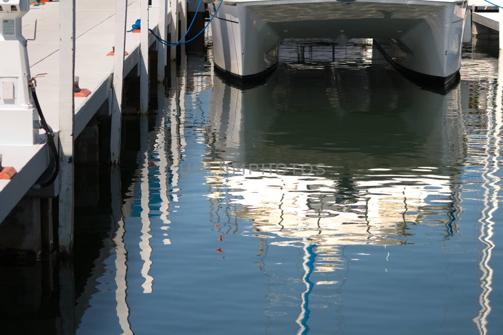 Marina Pier Reflections of a catamaran tied to the dock. 
