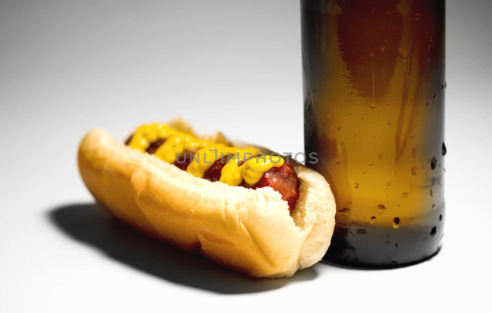 Hotdog with mustard and a cold beer