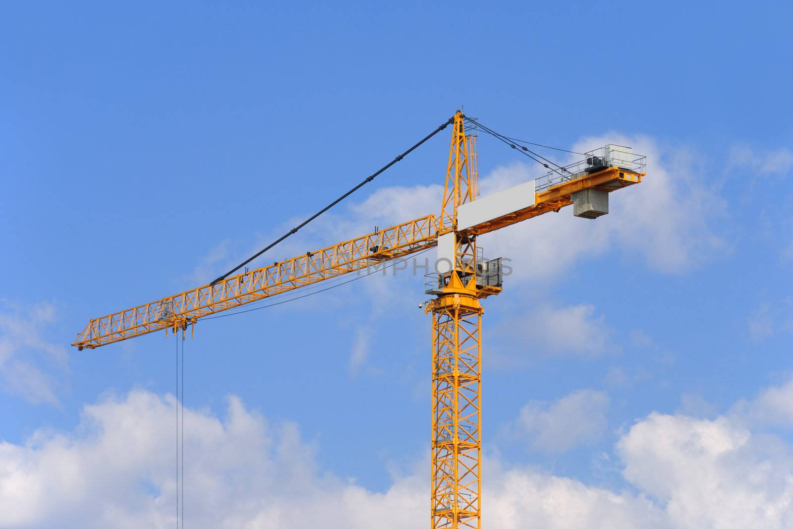 Yellow construction crane on a sky background.