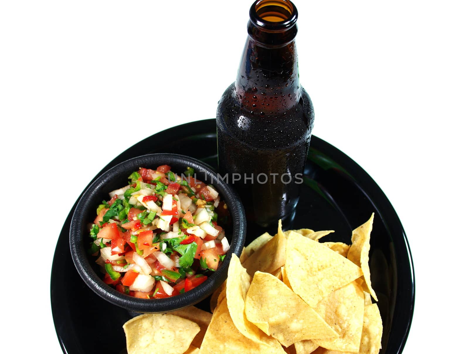 A cold beer woith chips and salsa on a serving tray.