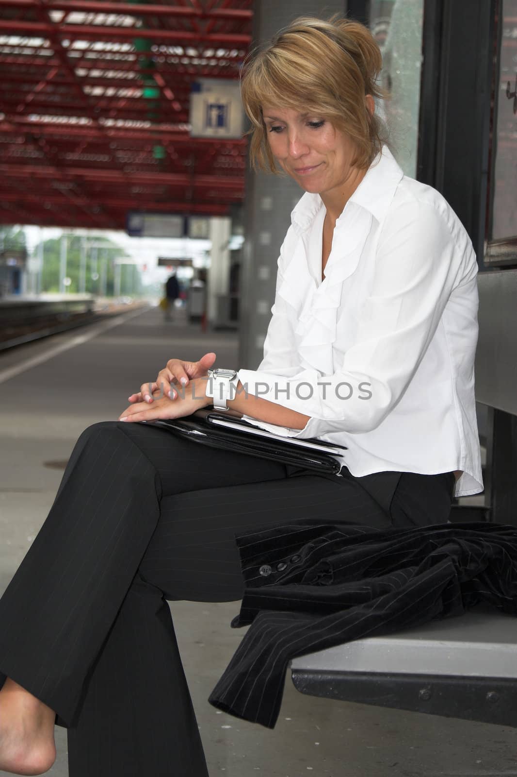 Businesswoman pulling an irritated face while waiting for the train