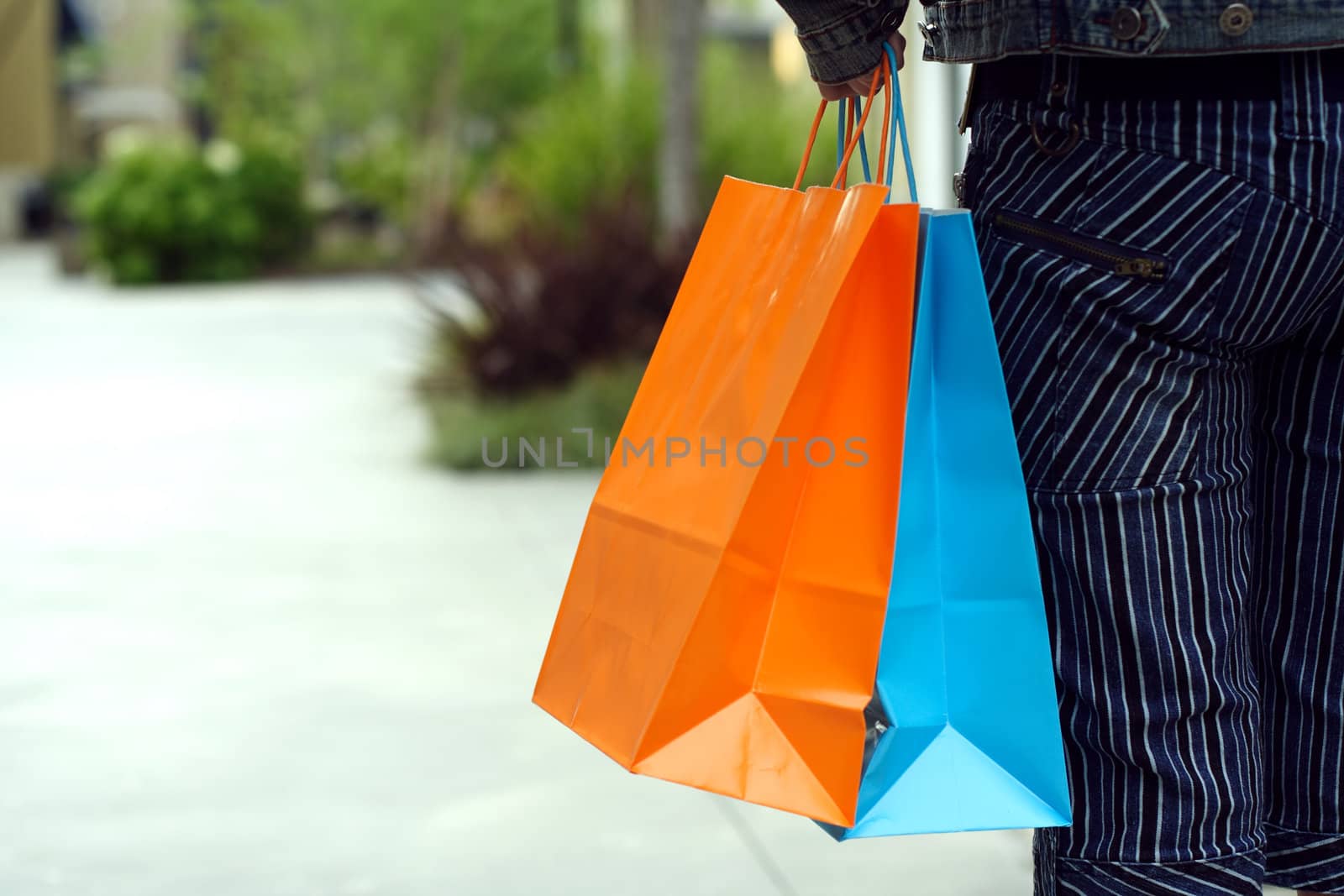 A woman shopping in a mall carrying shopping bags