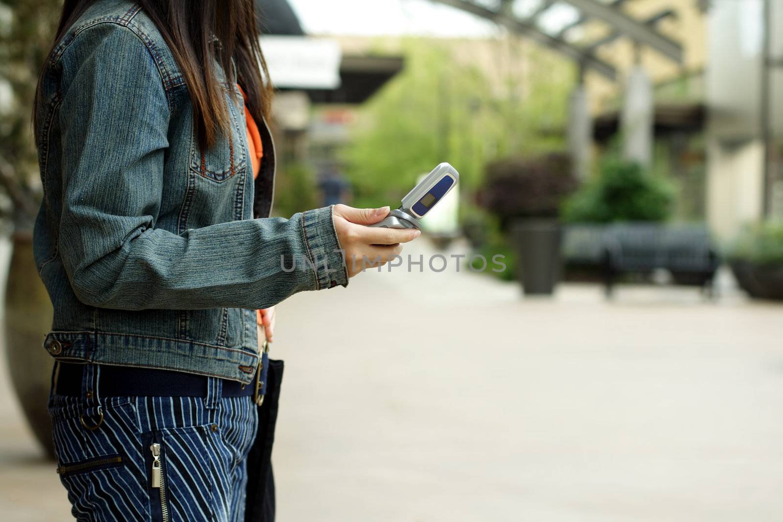 A woman with a cellphone in an outdoor shopping mall