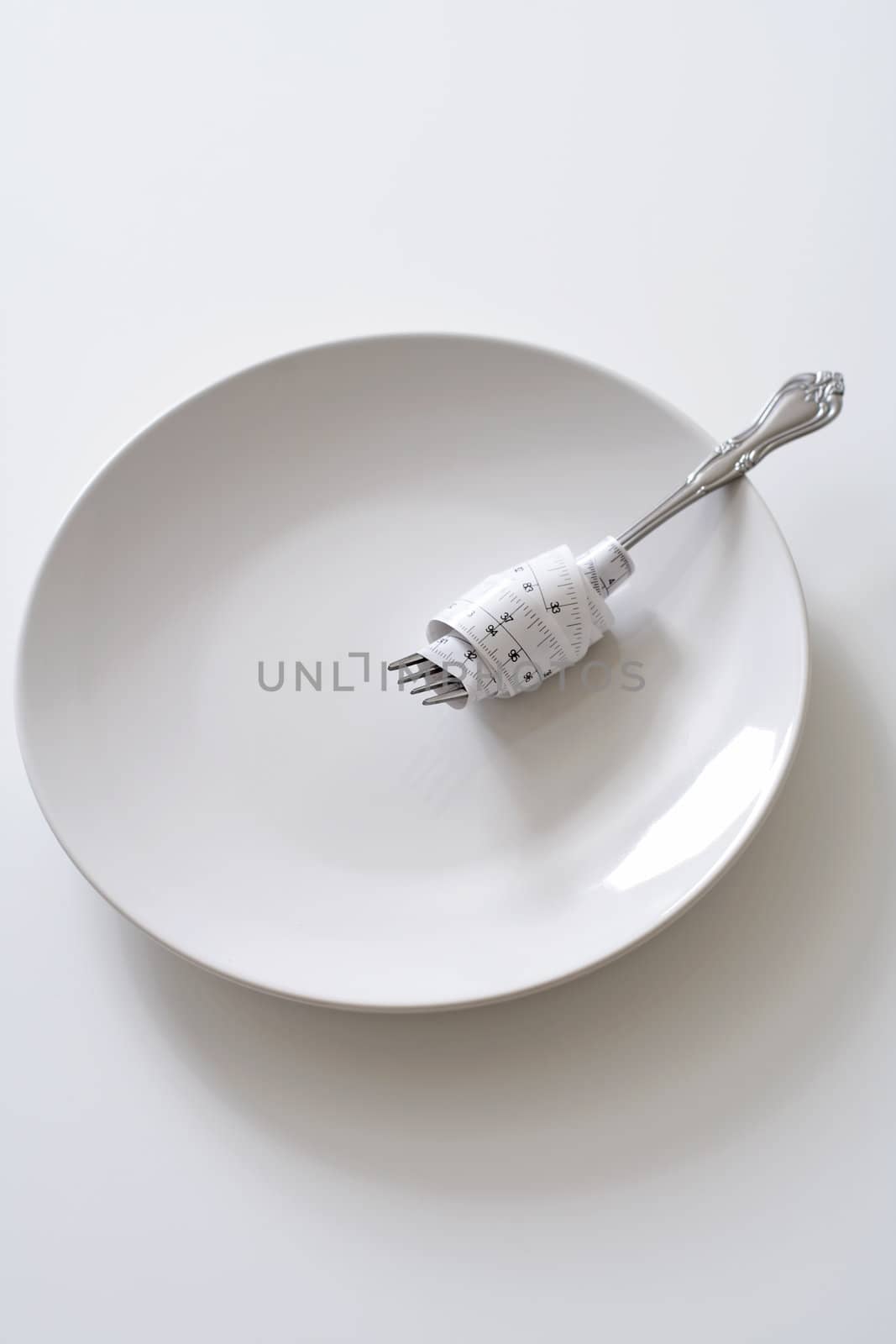 Fork with measuring tape on a plate