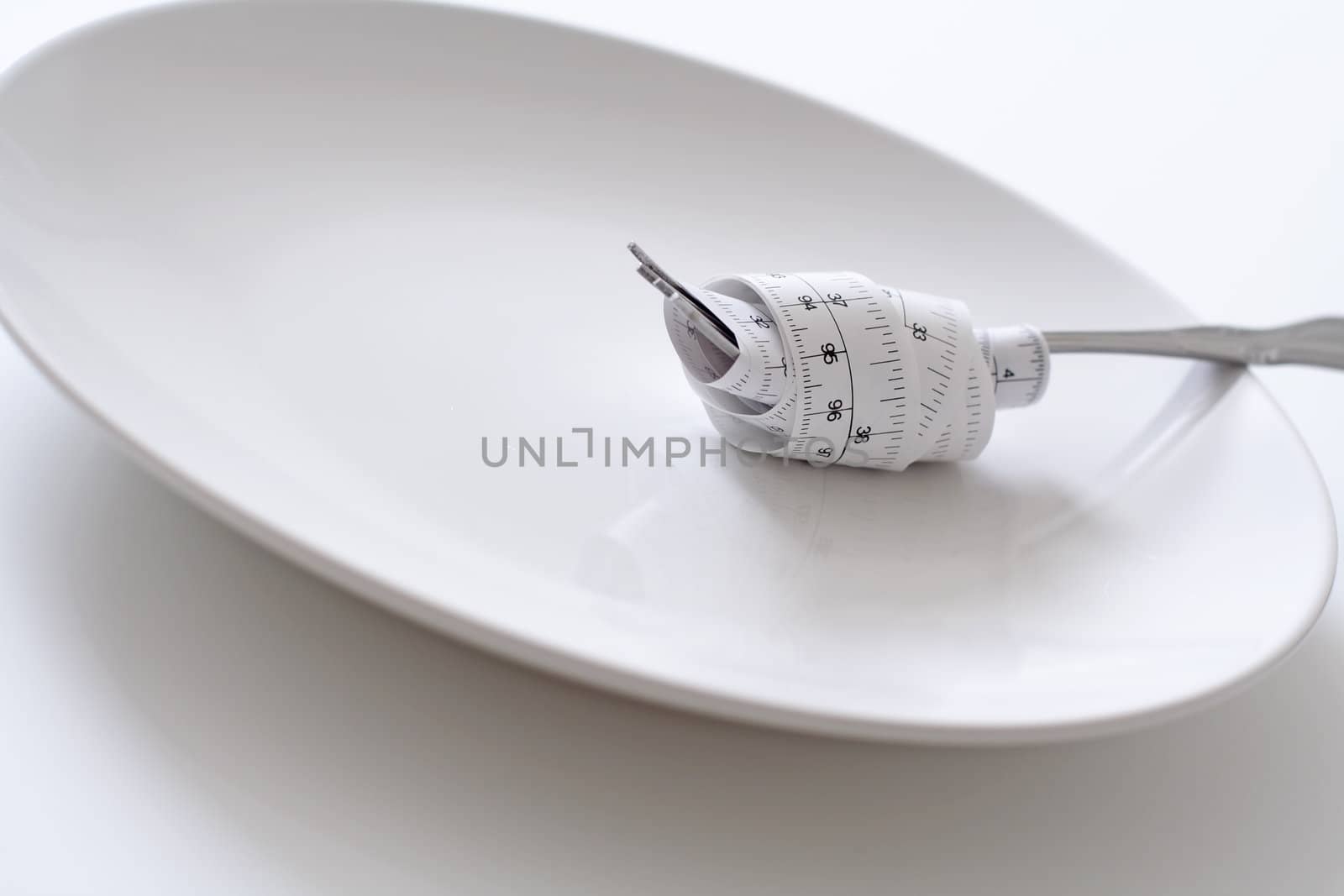 Fork with measuring tape on a plate