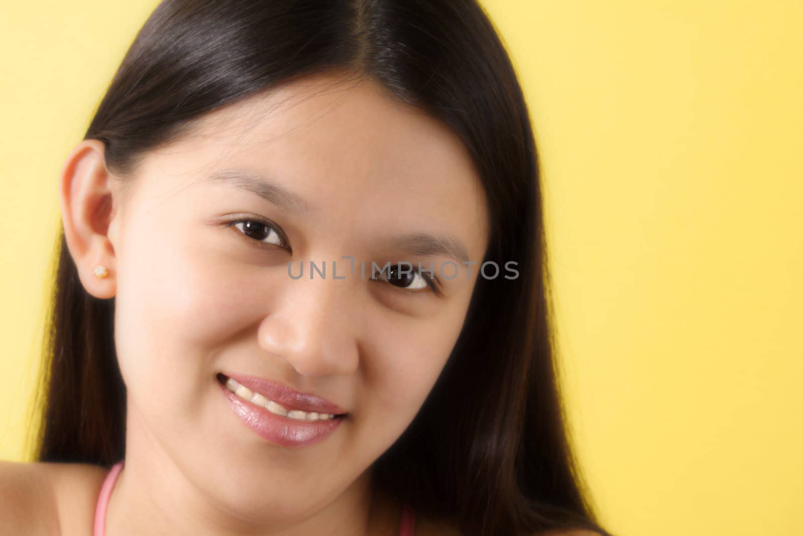 A portrait of a smiling woman with yellow background