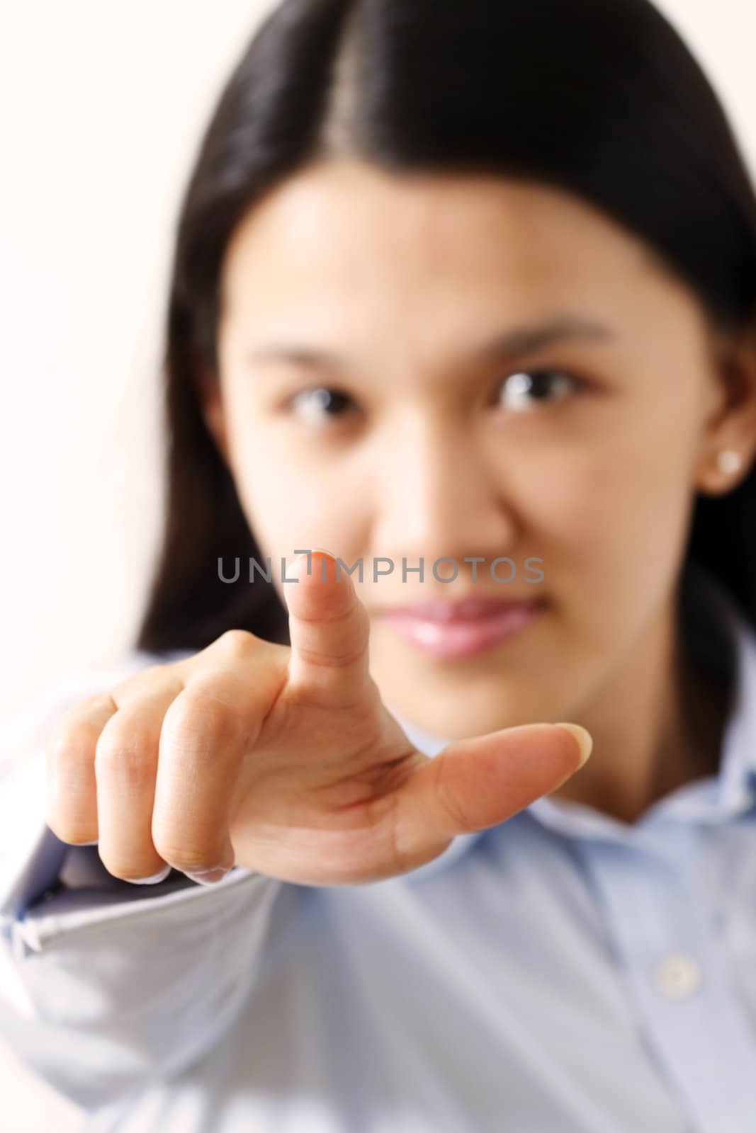 A businesswoman pointing (focus on index finger, shallow depth of field)