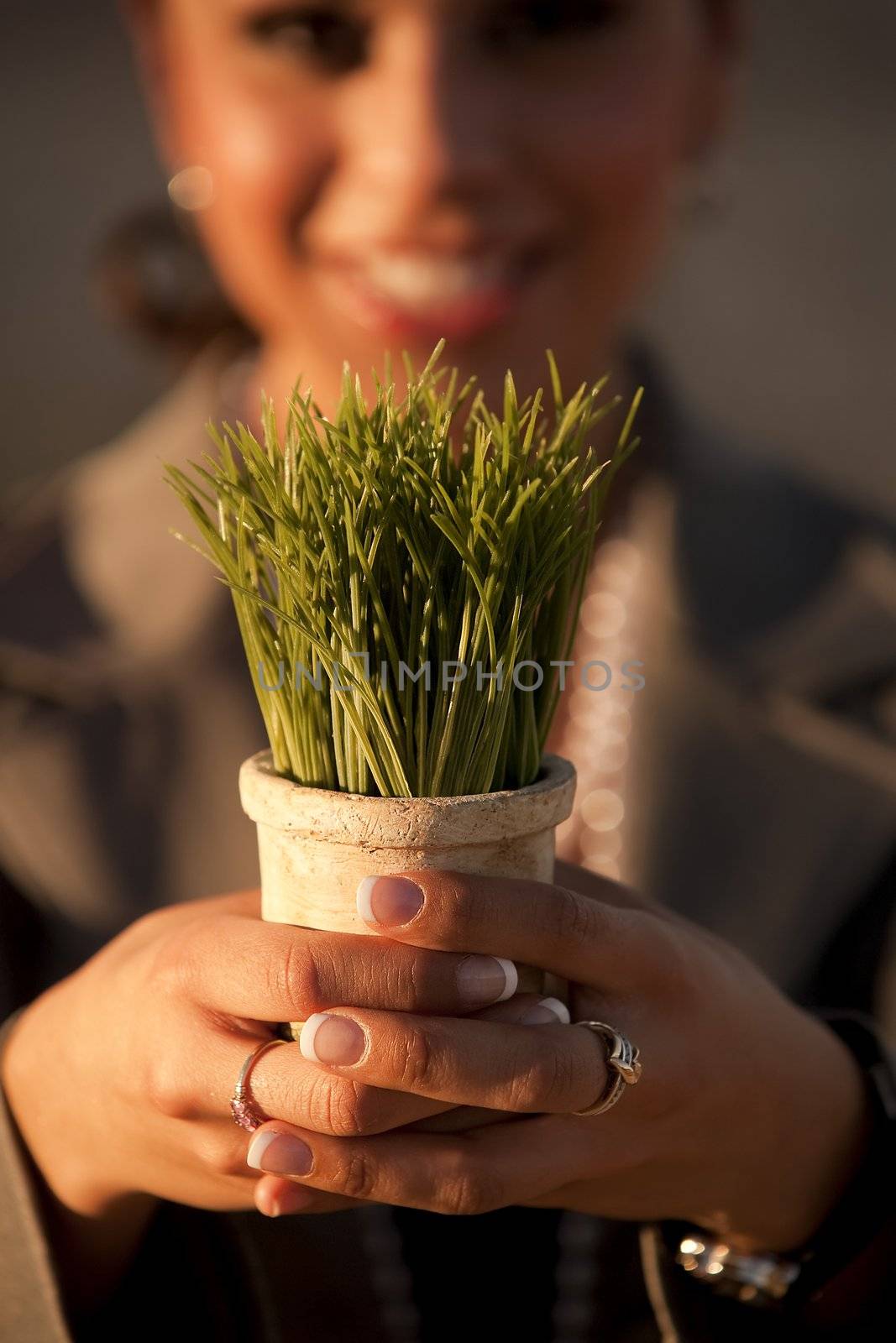 Shallow focus shot of woman holding plastic grass in pot