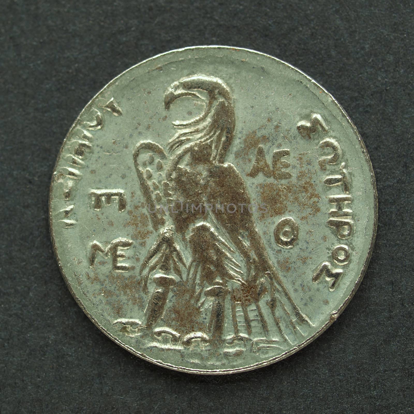Ancient Greek coin on a black background