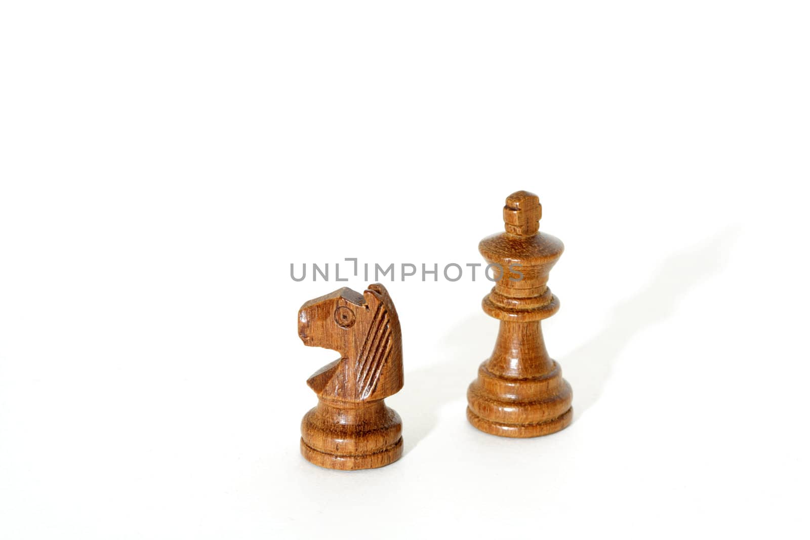 A horse and a king chess pieces on isolated white