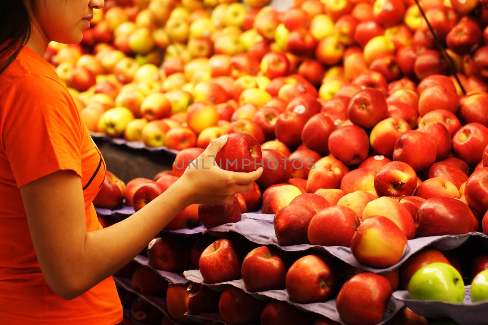 A woman shopping for apples at a grocery store