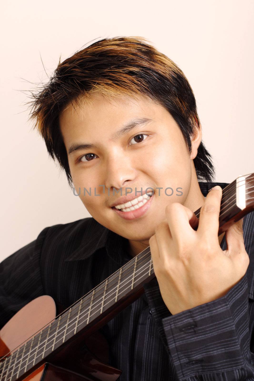 A handsome man holding a guitar