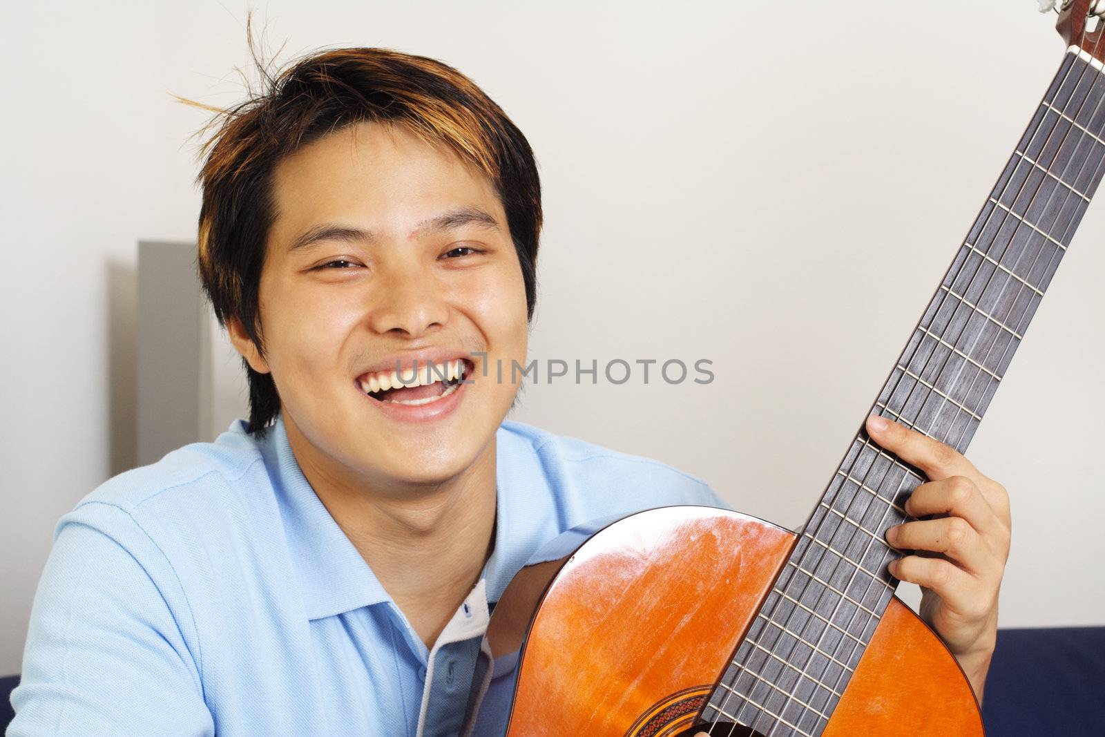 A handsome man holding a guitar