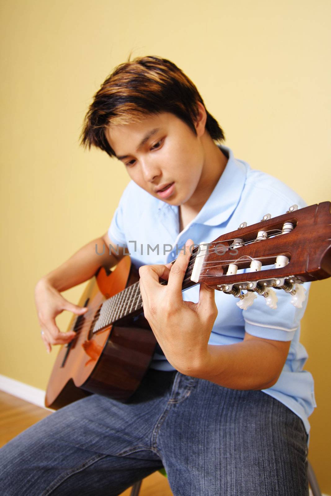 A young man playing guitar