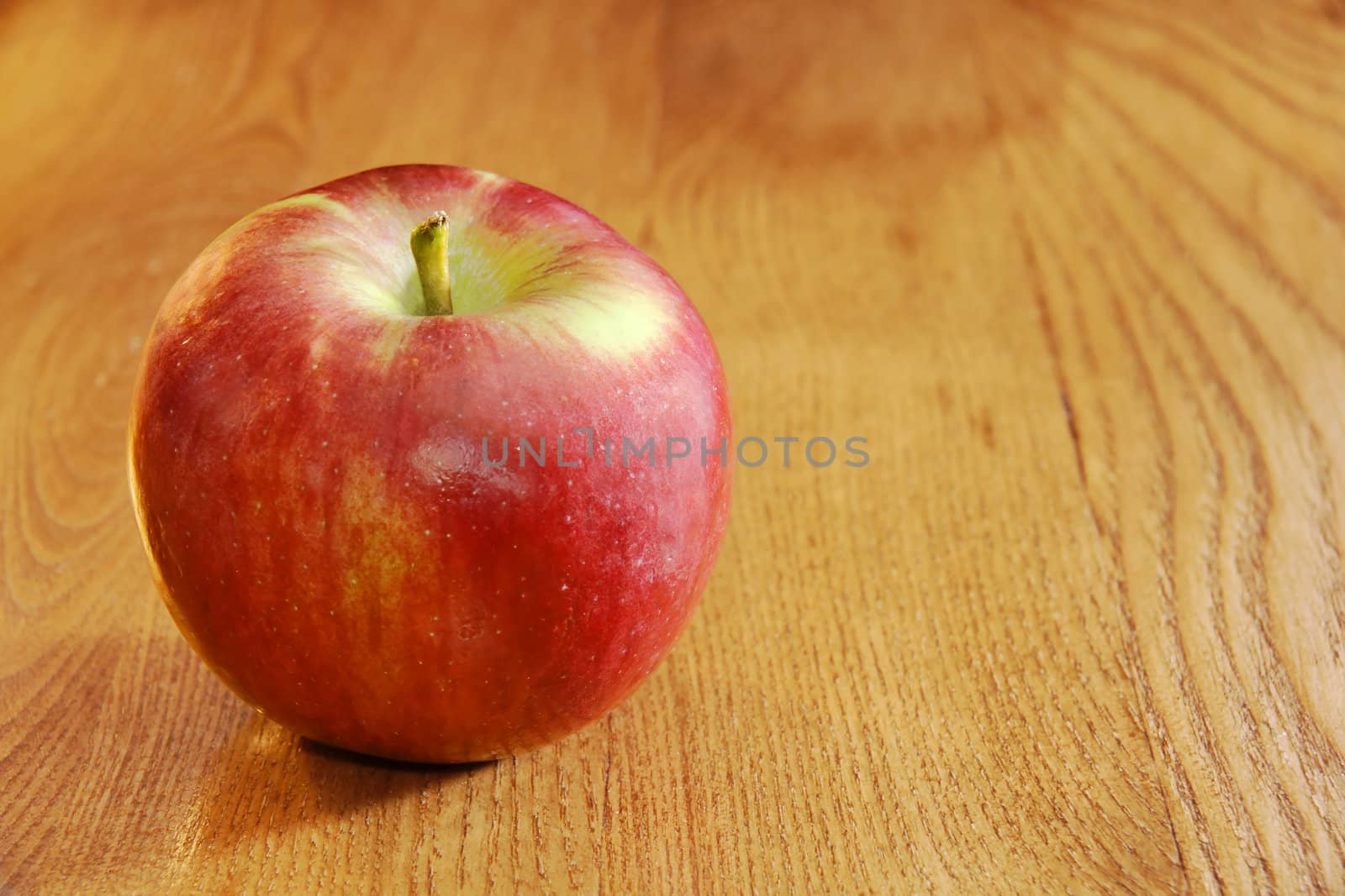 Healthy food: bright red cortland apple on wooden table.