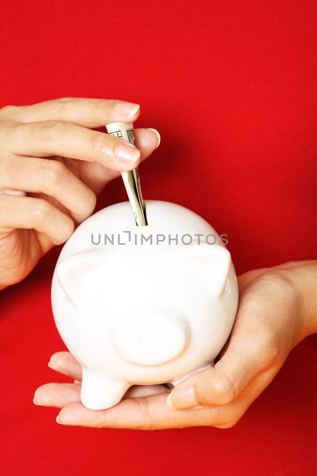 A woman depositing money into a piggy bank