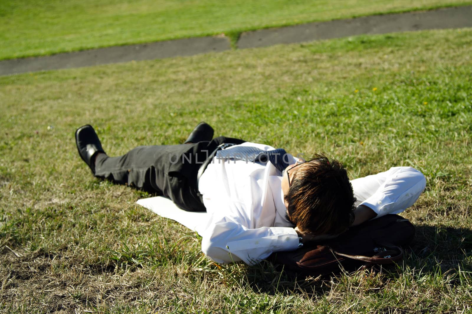 Businessman taking a nap in a park