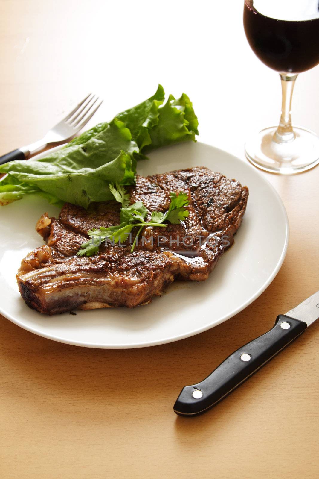 Grilled ribeye steak with a glass of wine