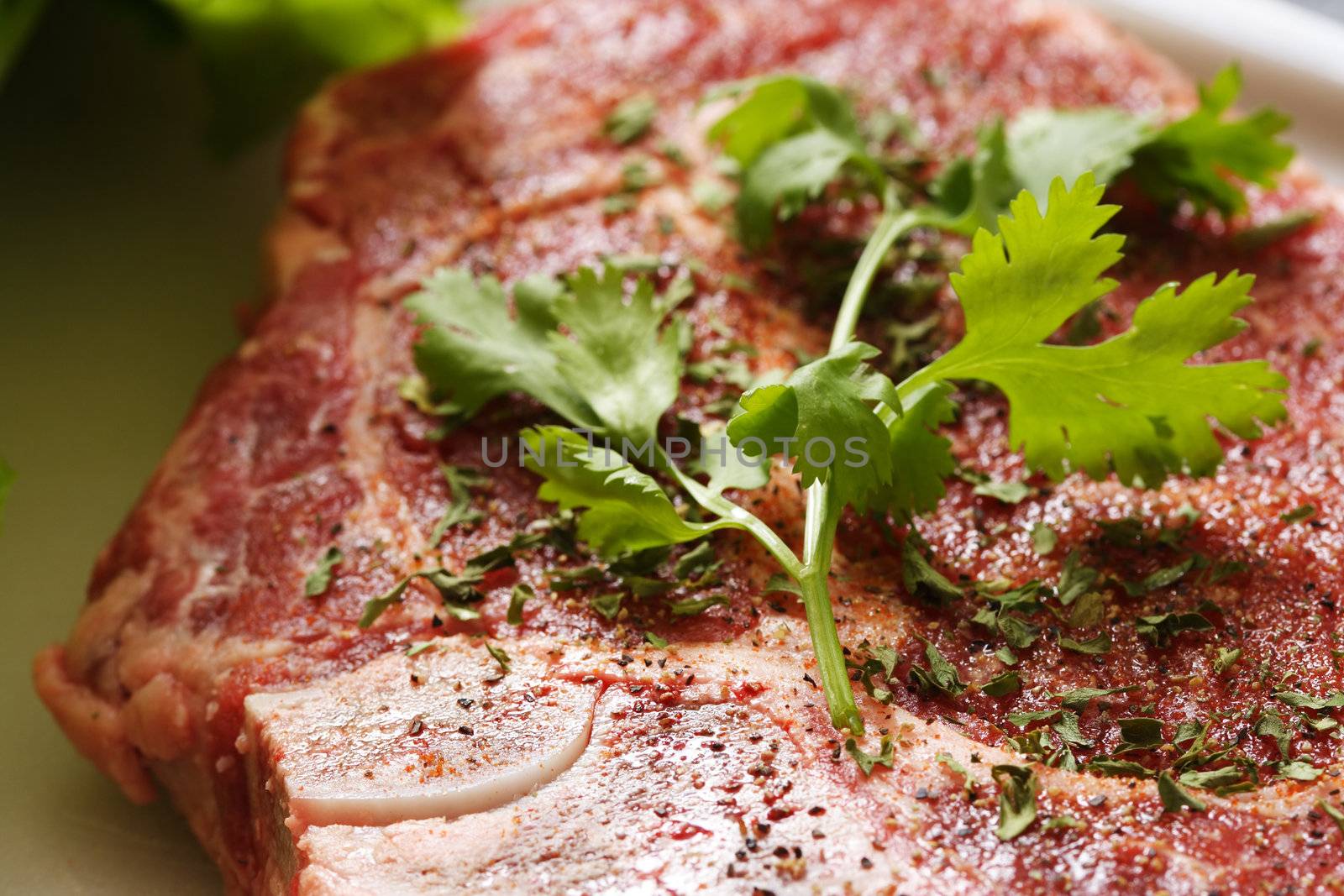 Seasoned ribeye steak being prepared for cooking