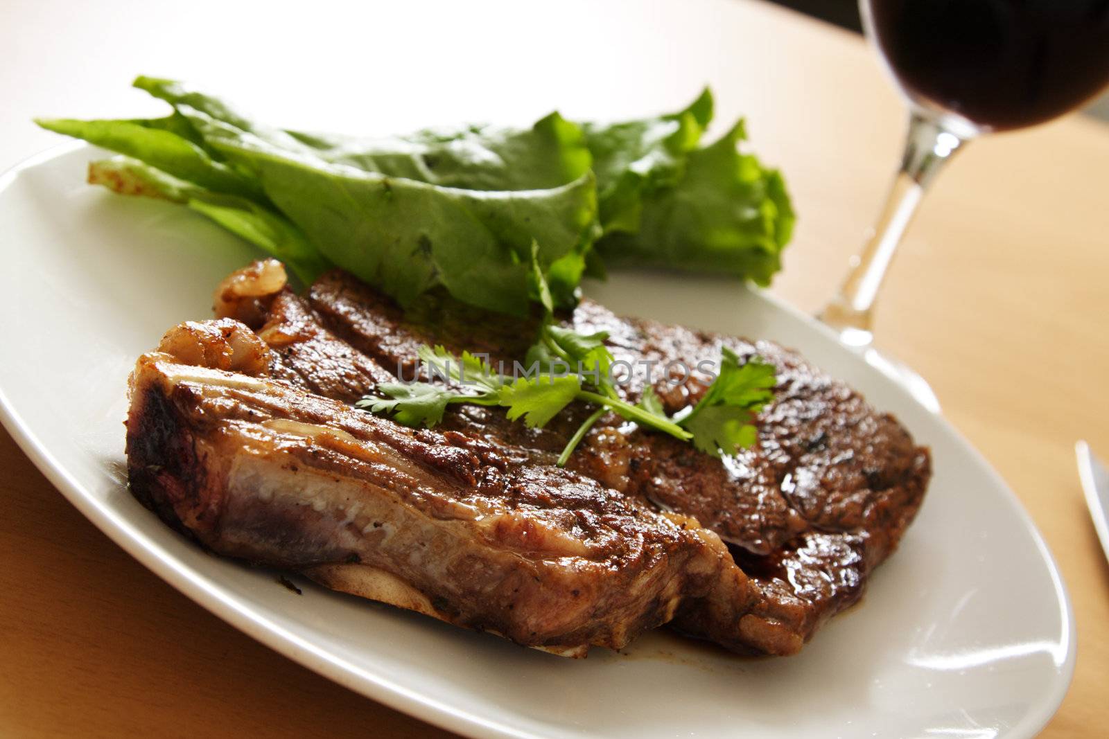 Grilled ribeye steak with a glass of wine