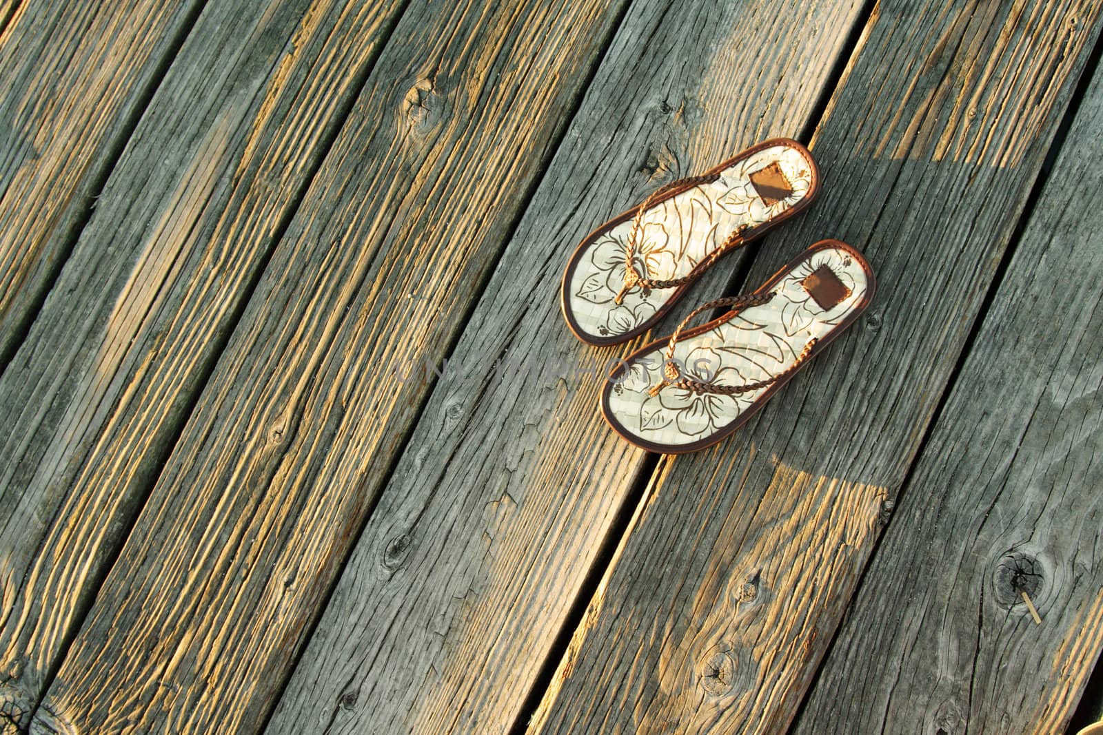 A pair of sandals on a boardwalk