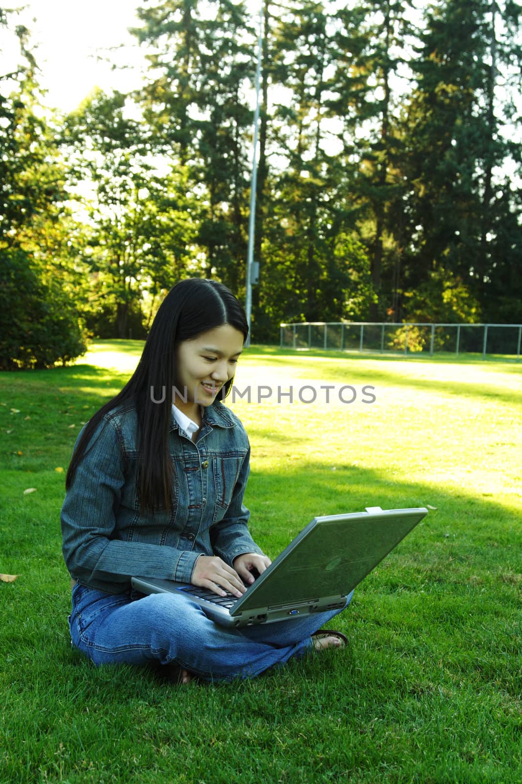 A girl sitting in a park with laptop