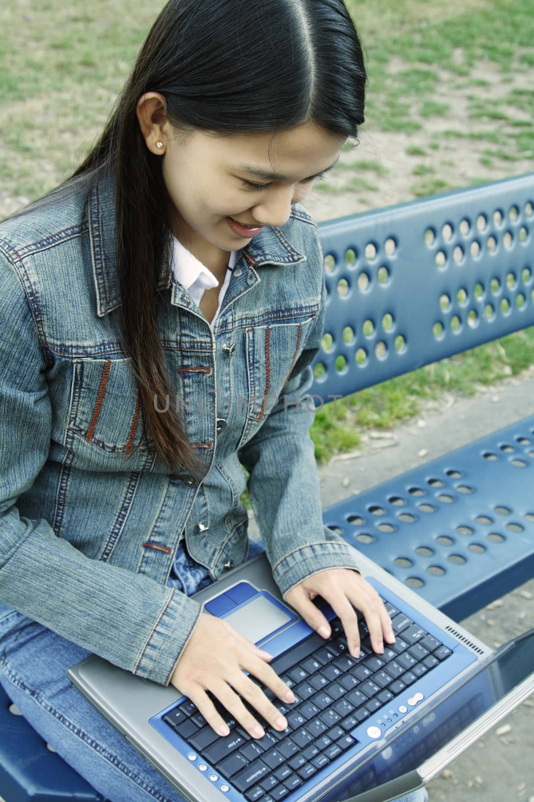 A girl working on her laptop at a park