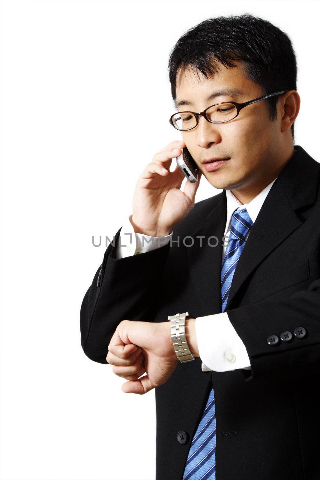 Businessman talking on a phone while watching his watch