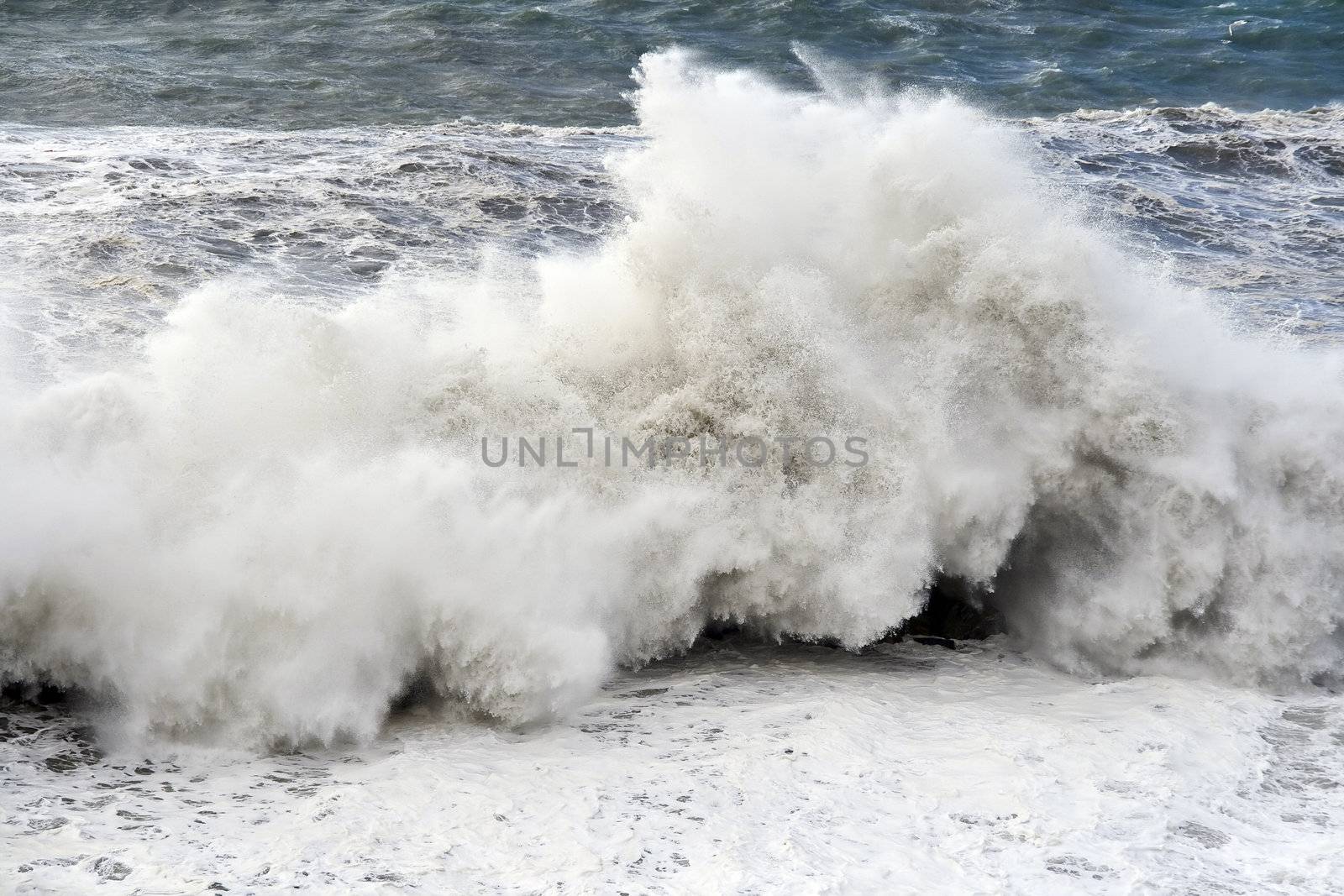 Giant wave breaks on the lighthouse during a storm in Mediterranean sea