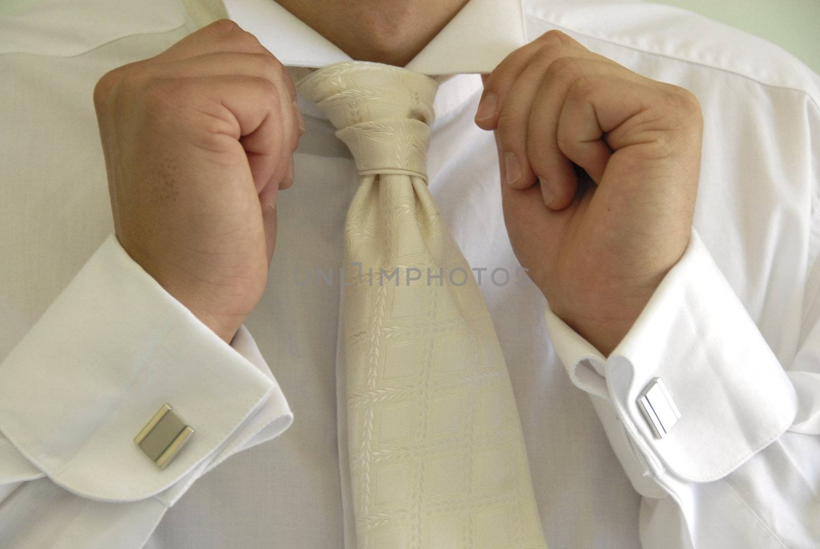 male hands with cuff links in shirt holding white collar