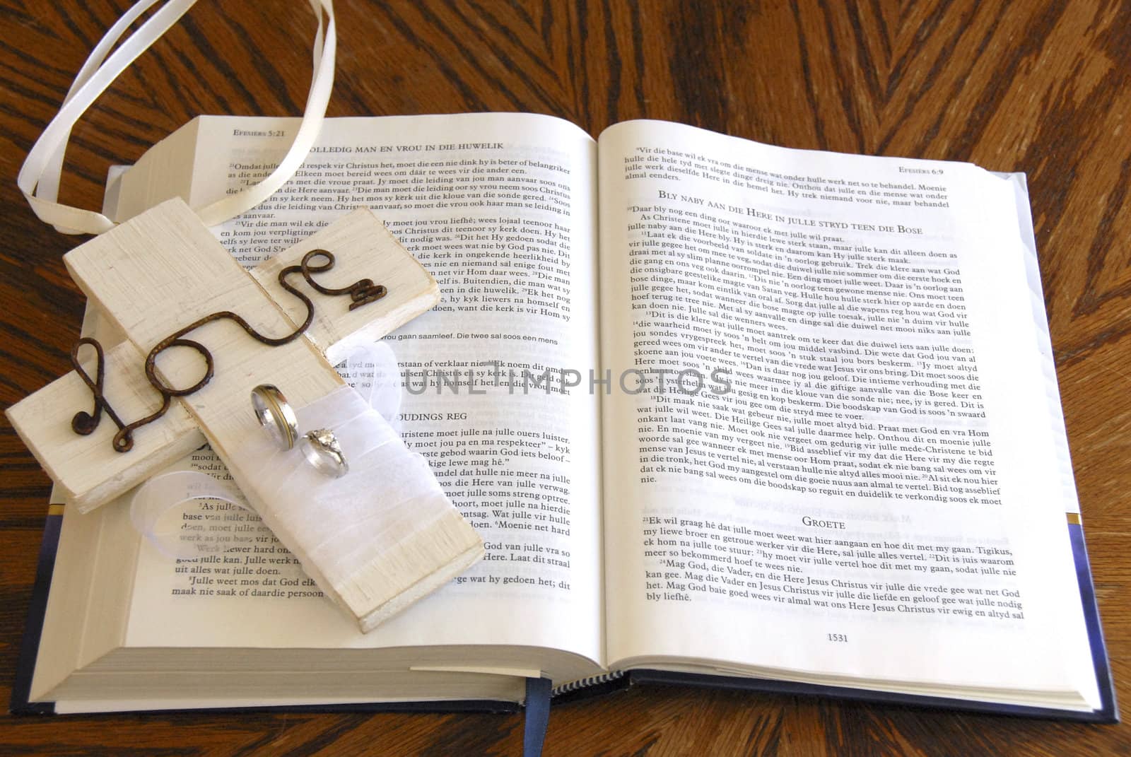 white love crucifix with rings laying on open bible