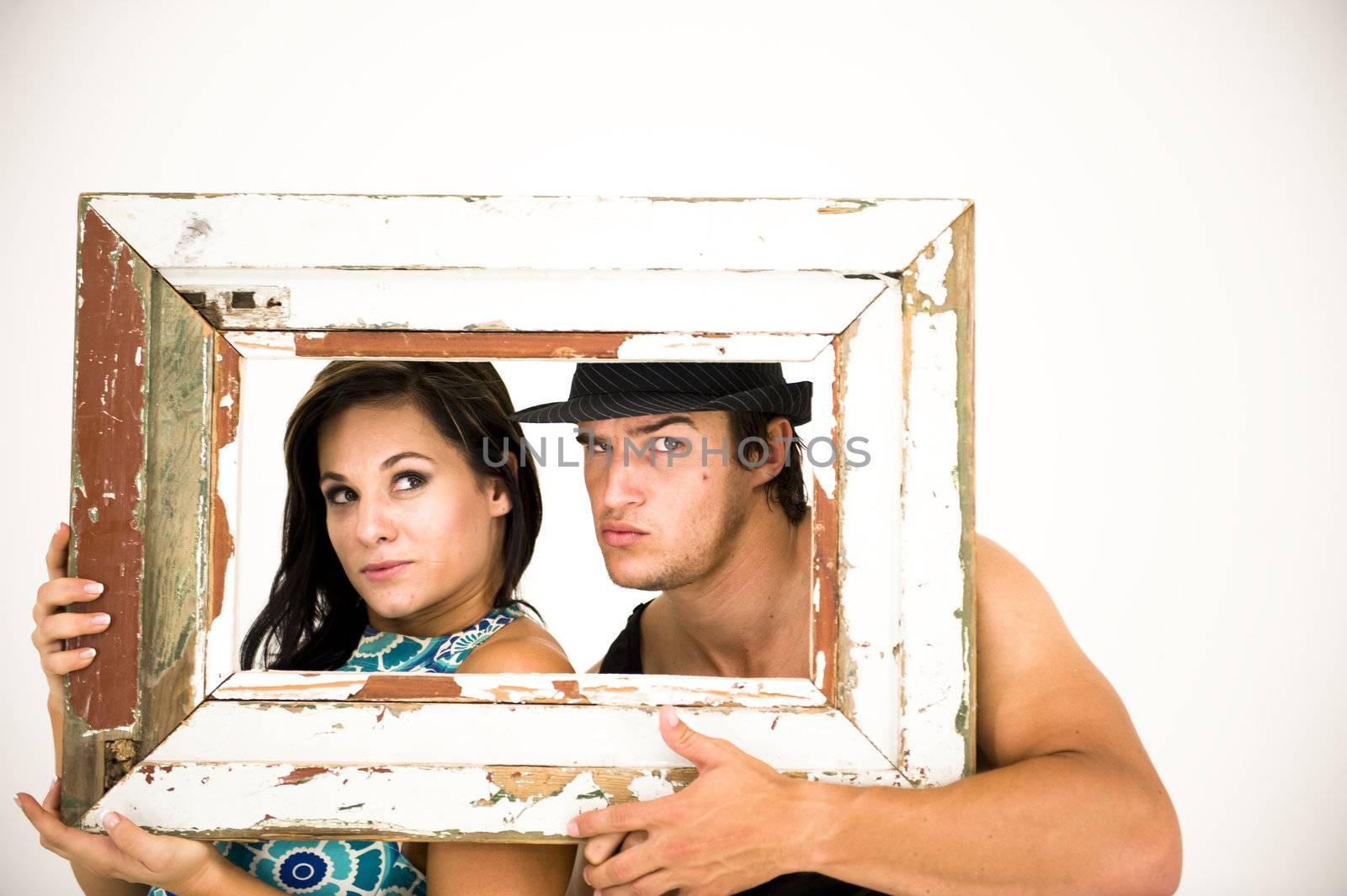 Young couple looking through a rusted old picture frame