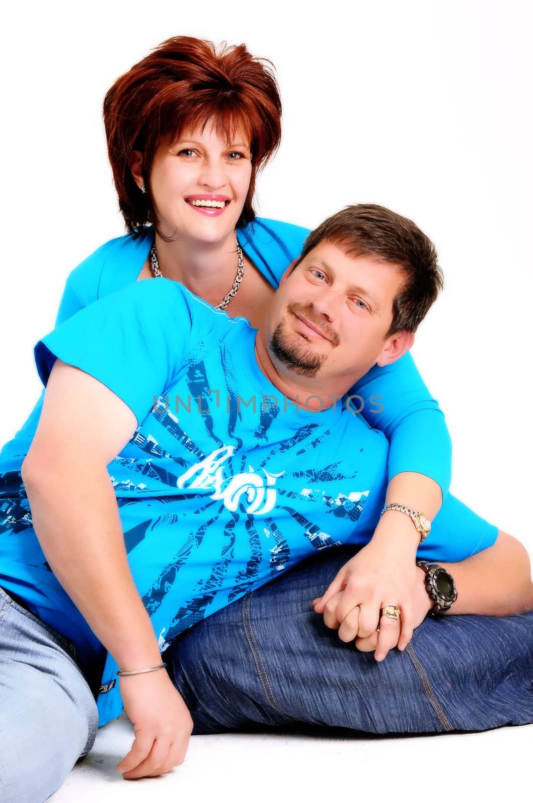 married couple with husband leaning on wife's lap and smiling