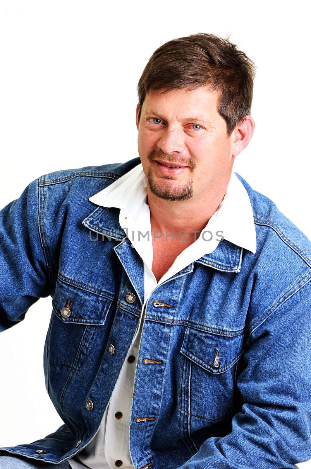 portrait of handsome male model with beard and smiling wearing a jeans jacket