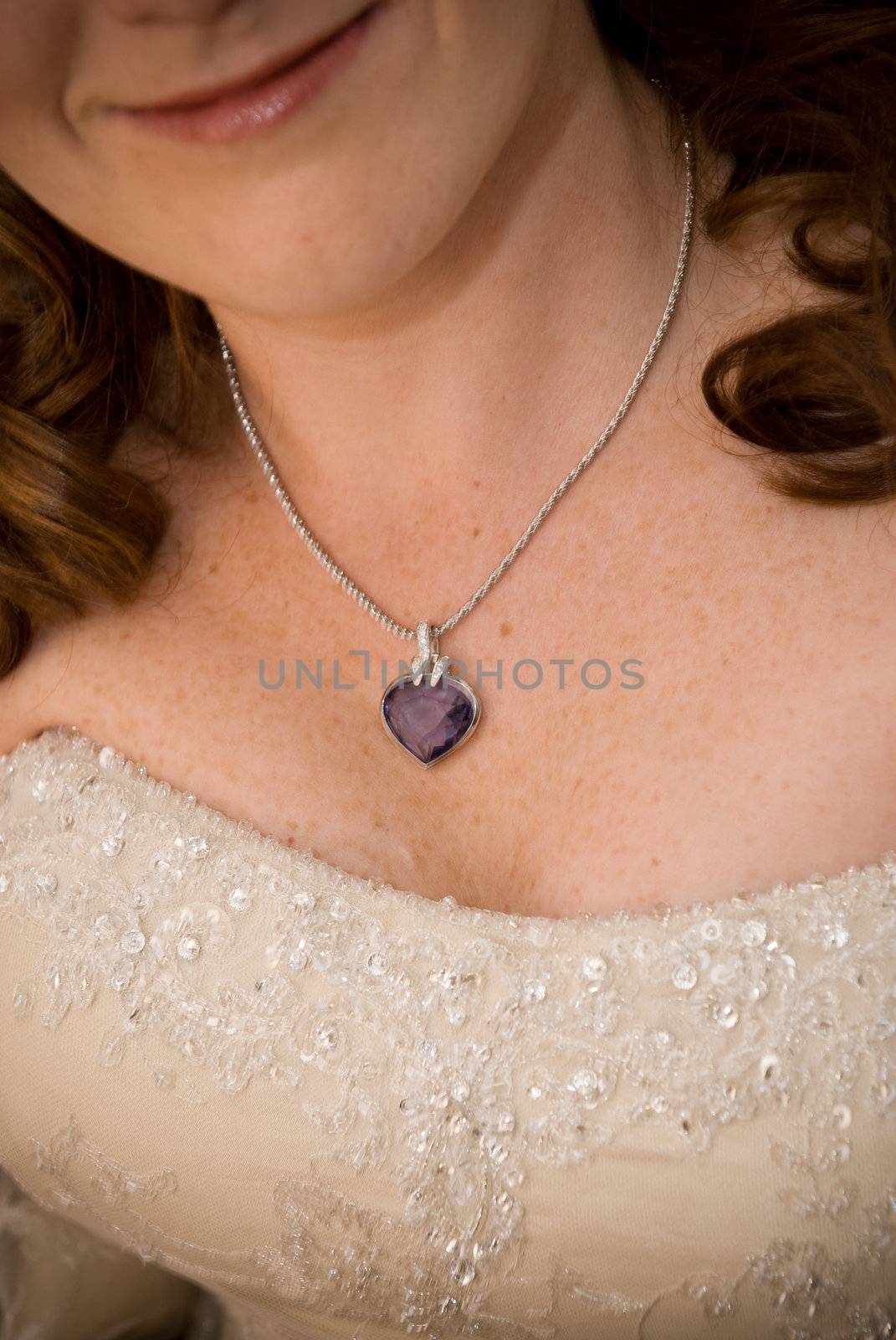 sexy red head bride showing her purple stoned necklace and cleavage