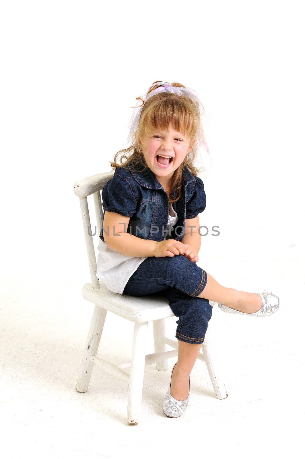 Pretty blond girl in blue dress sitting on white chair by Ansunette