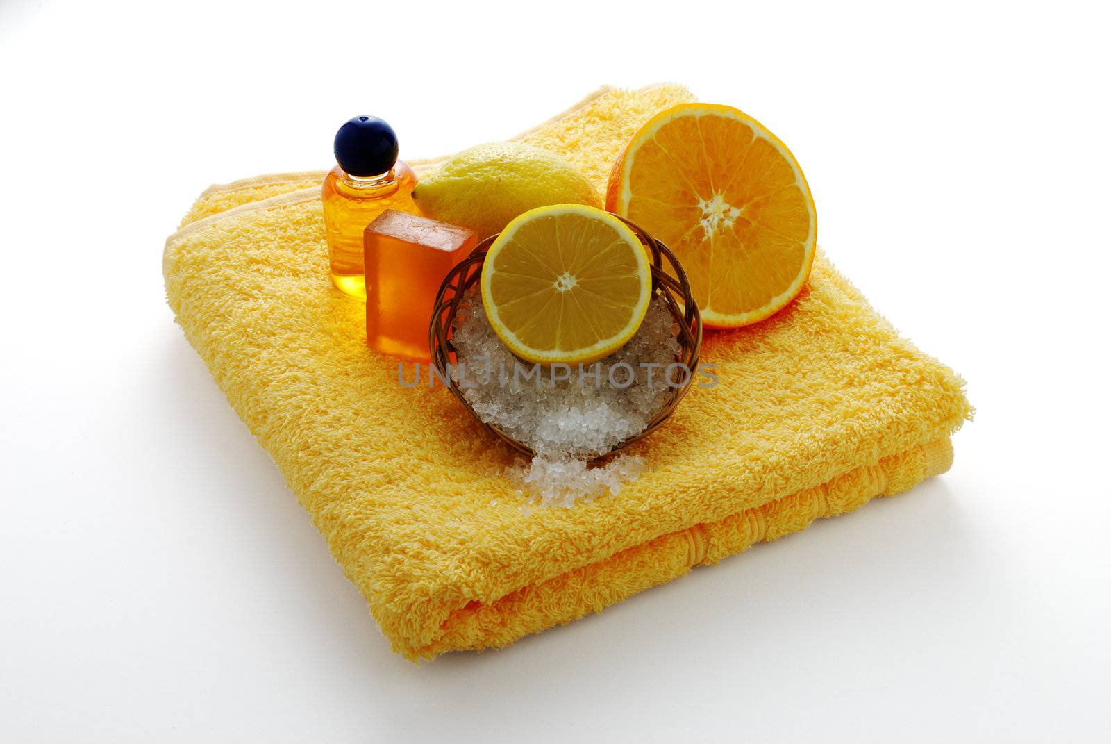 Citrus flavored SPA set including soap, salt and  shampoo on yellow towel