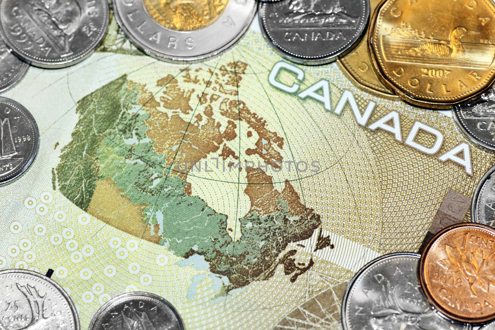 Close up of a one hundred canadian dollar bill showing the map of Canada, surrounded by loony and tuney coins.