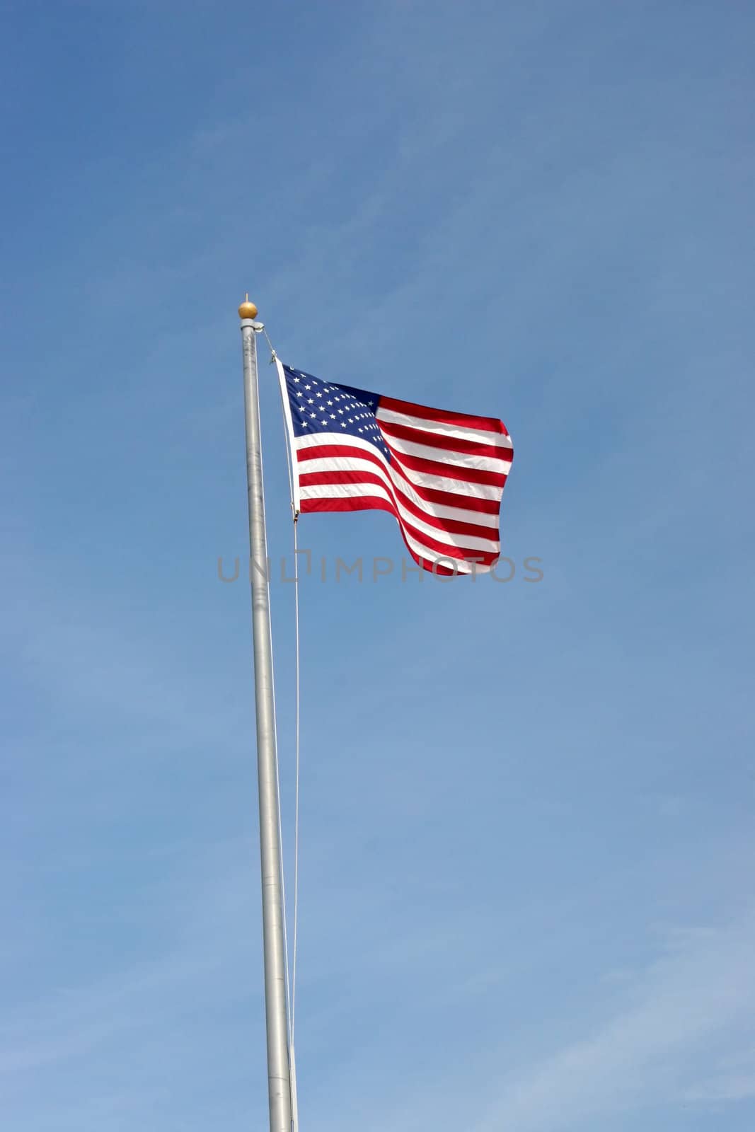 An American Flag flying in the air up a pole