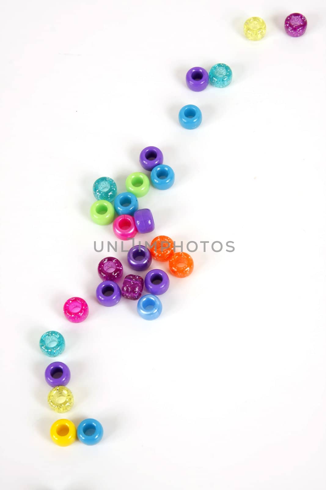 Colorful beads scattered on white background.