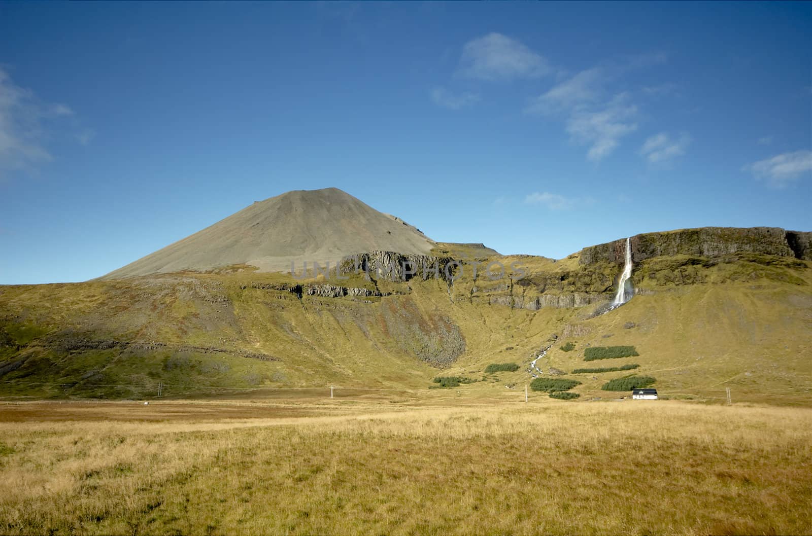 Icelandic countryside scenery with farm and waterfall