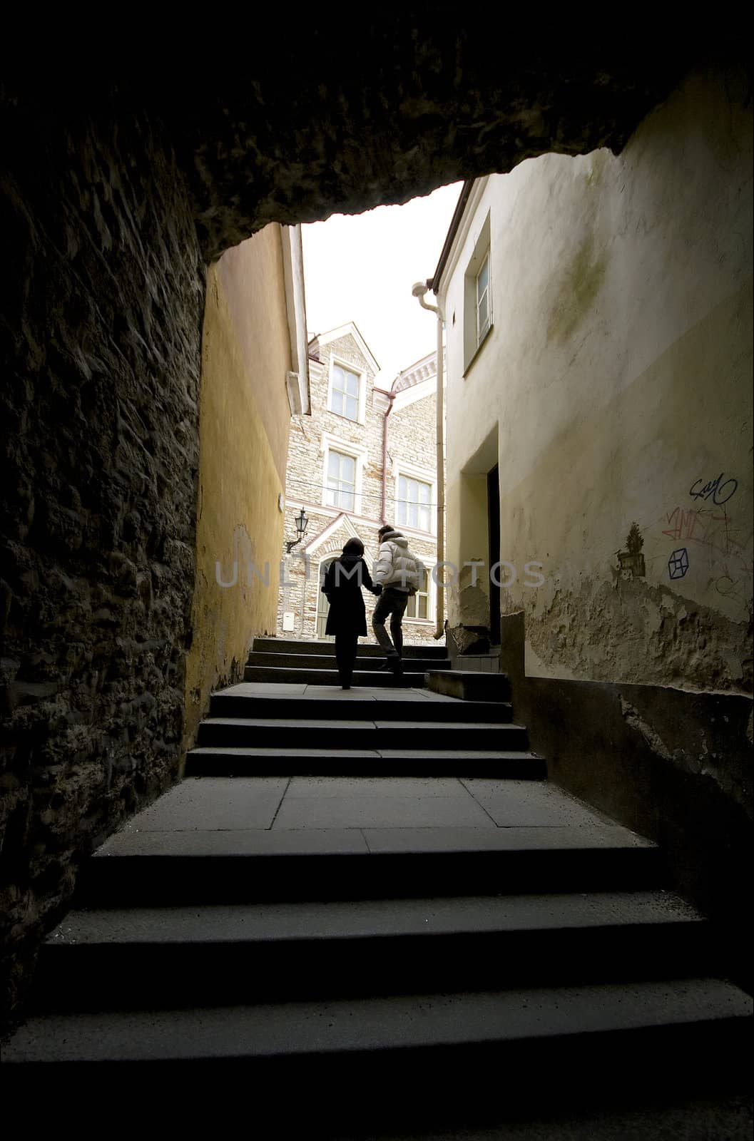 Couple walking in ons of Talliin's Old Town alleys