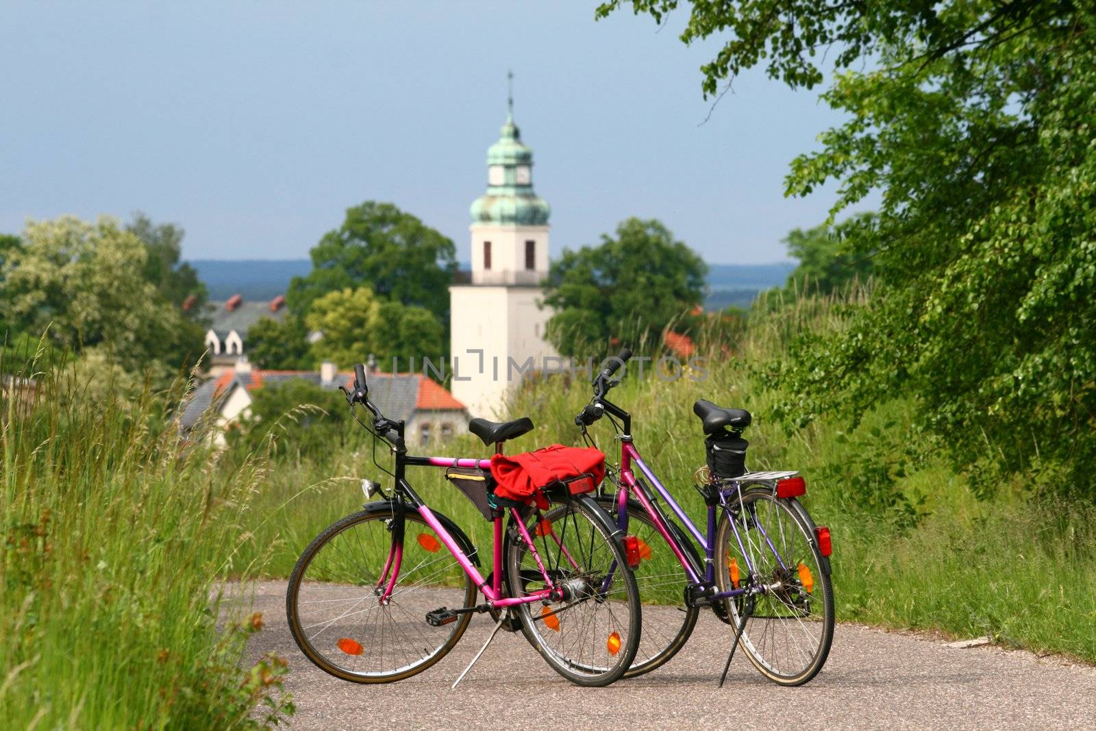Two bikes standing on the road with a church in background - break during bicycle trip