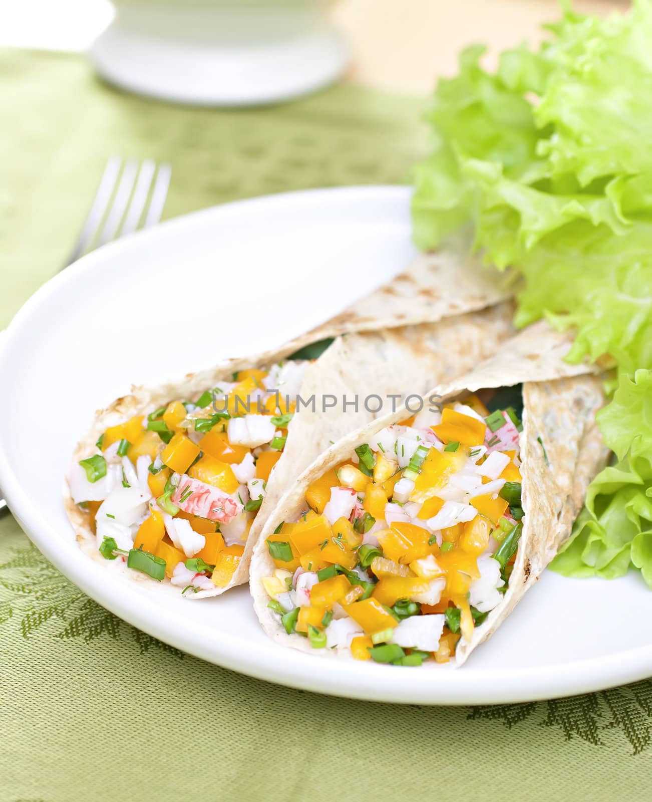 Served wheat wraps filled with salad and crab meat.
