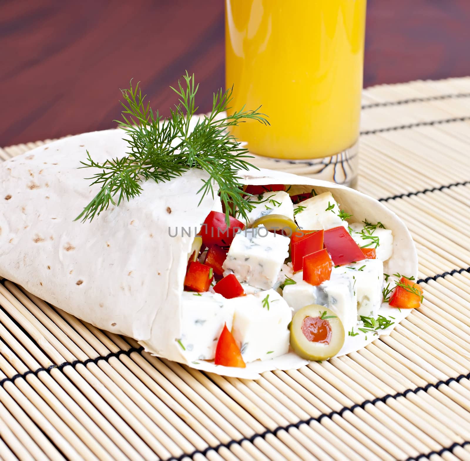 Lavash with a cheese filling and a glass of juice.