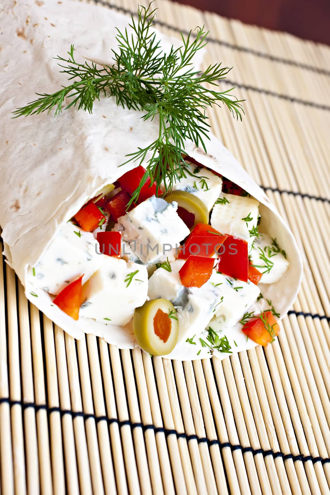 Lavash with a cheese filling, tomato, peppers, olives and fennel.