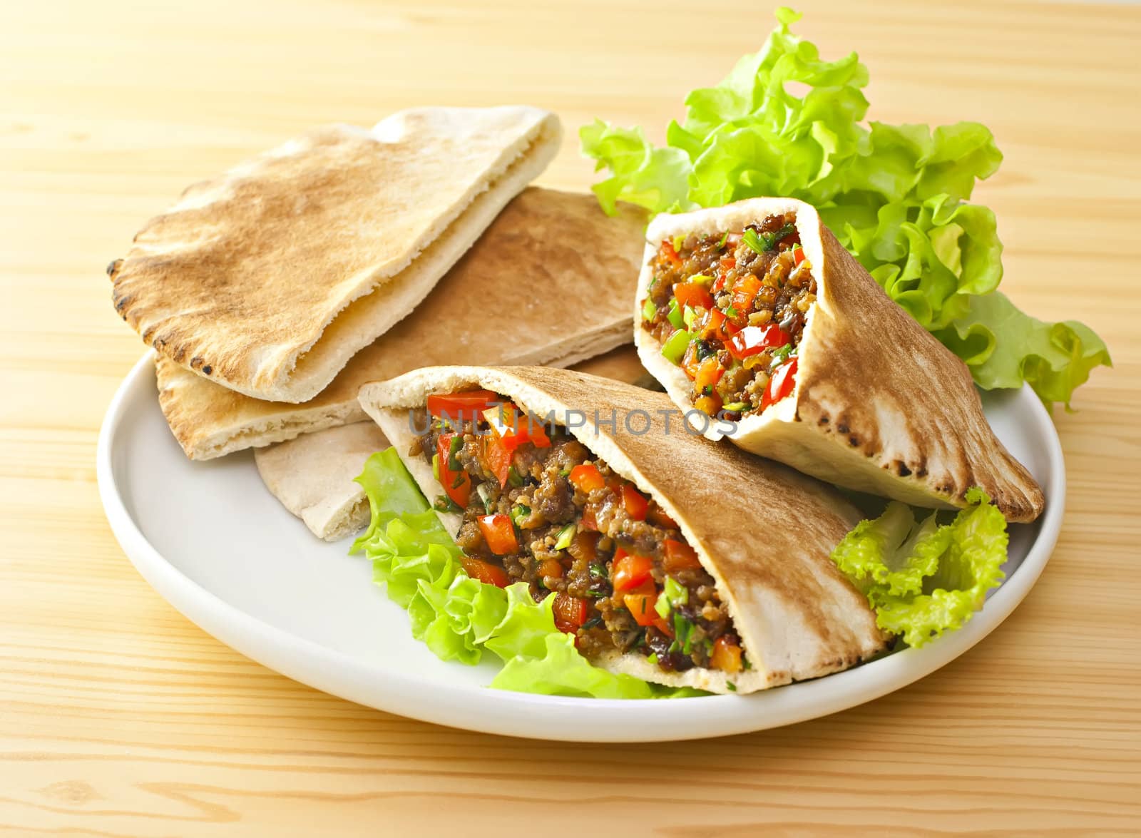 Pita bread with grilled meat and fresh salad.