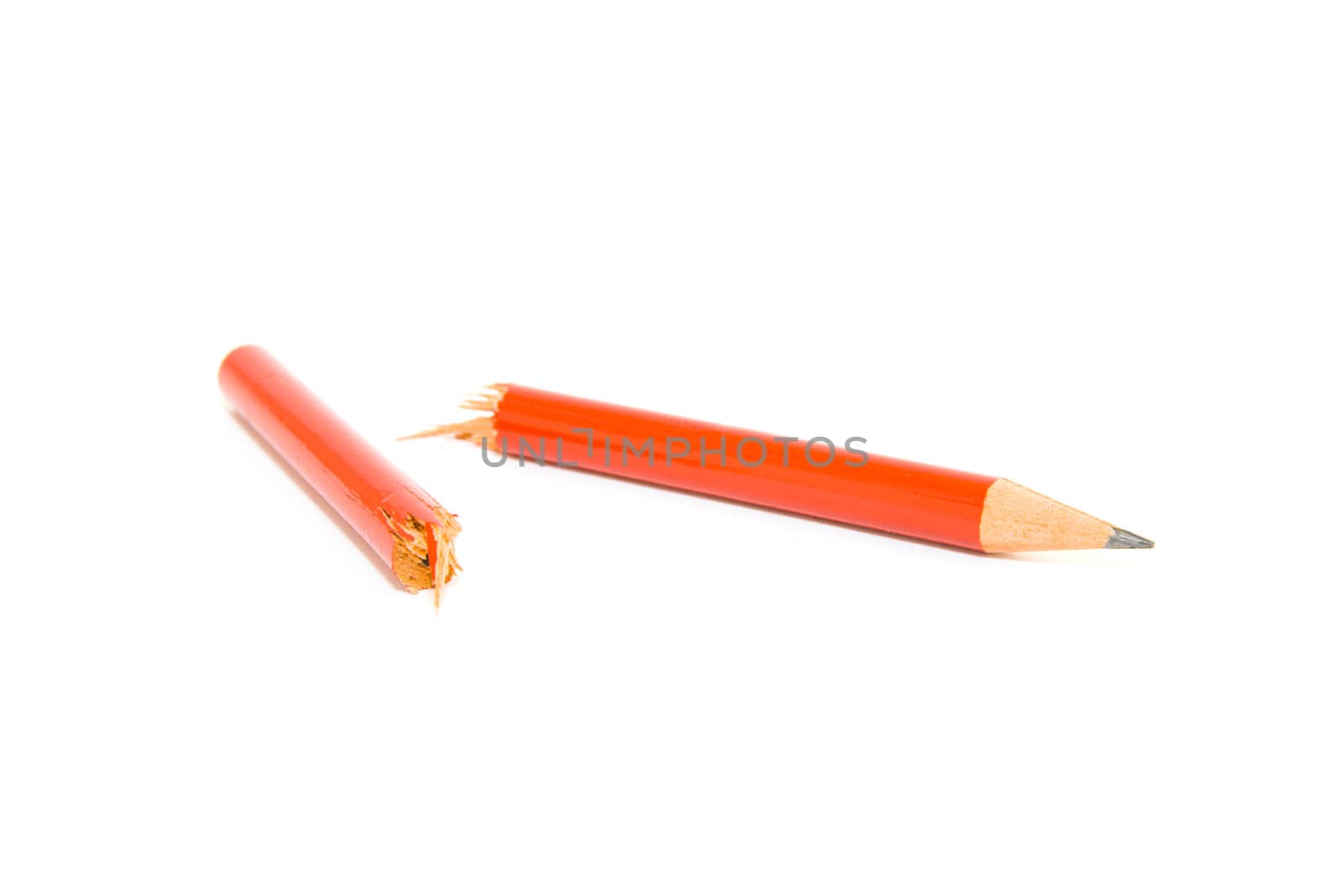 Red pencil snapped in two halfs on a white background